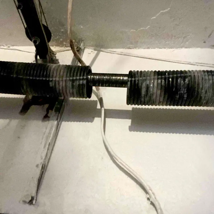 Broken torsion spring with a visible separation before replacement in Tulsa, OK