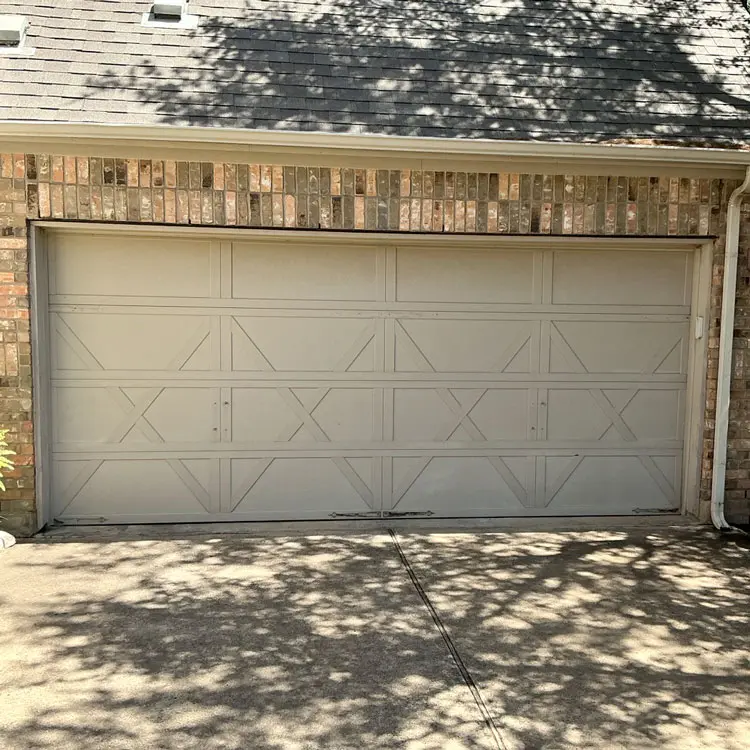 Aging wooden garage door with developing rot before replacement in Austin, TX
