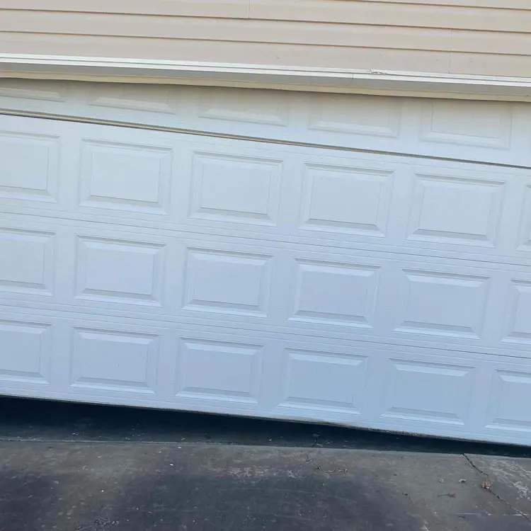 Crooked garage door sitting unevenly after coming off track at a Tulsa, OK home