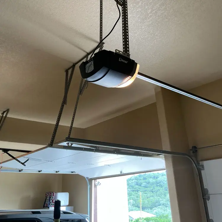 Garage door and opener receiving preventive tune-up and maintenance in San Antonio, TX