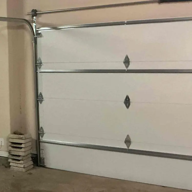 Two white double-steel garage doors before a wood-grain carriage-style upgrade in Tulsa, OK