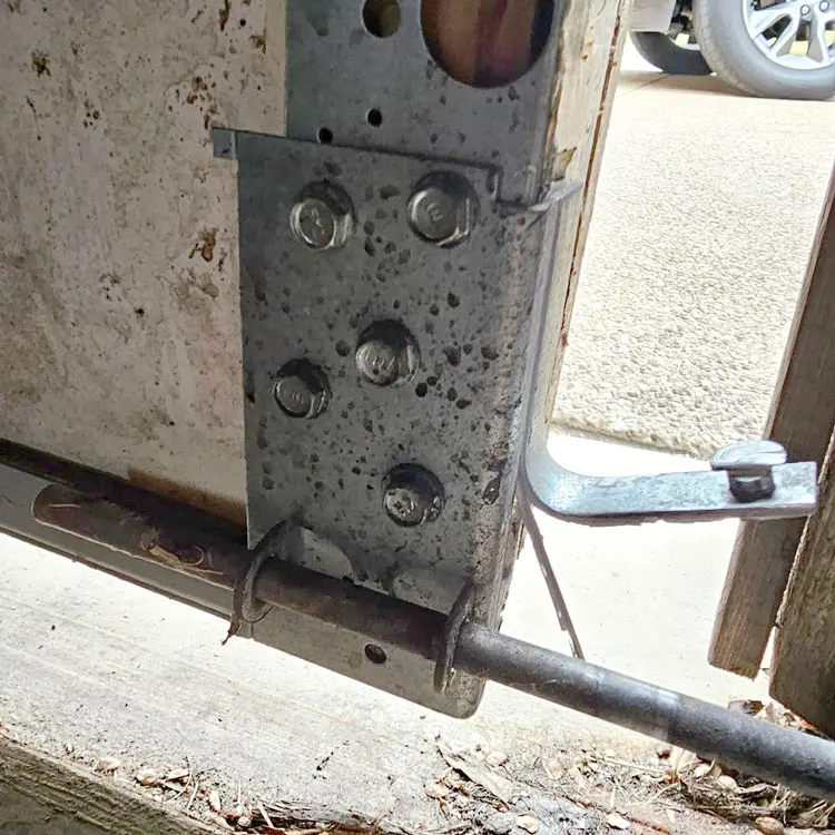Damaged garage door bottom bracket before replacement in Fort Worth, Texas.