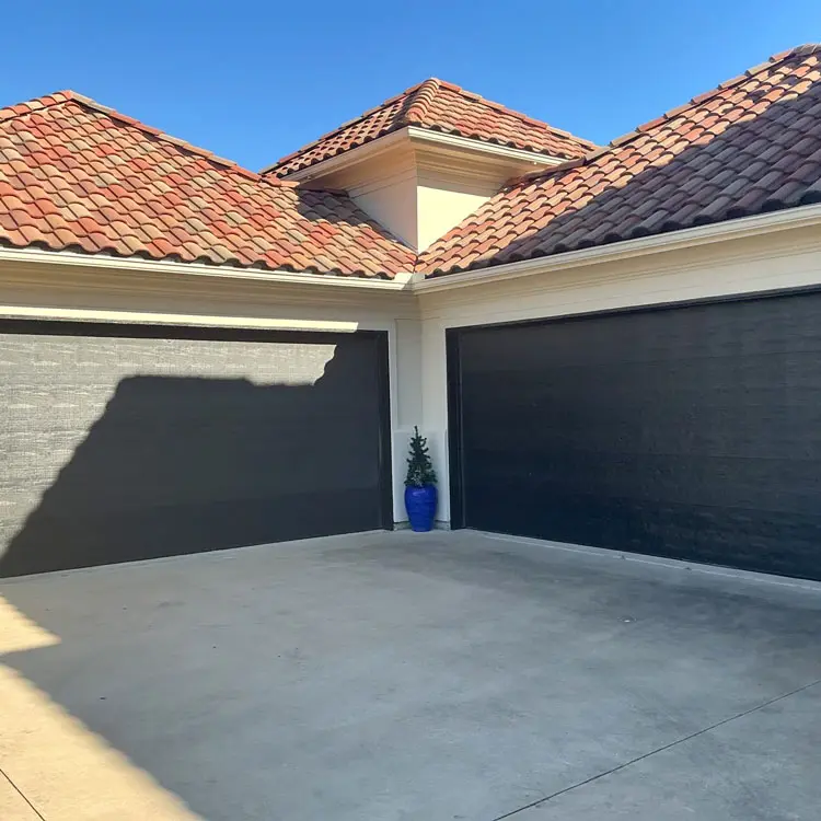 Two dark flush-panel garage doors before replacement with modern doors with windows in Tulsa, OK