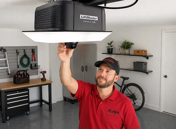 Experienced garage door technician syncing the garage door opener to the door and remotes.