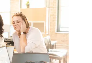 Prestige team members in office smiling at something on a computer