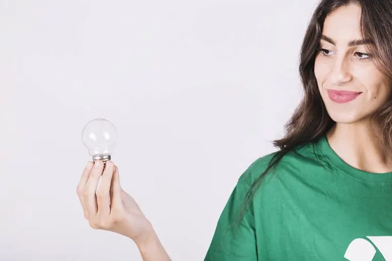 A woman holding a lightbulb on a white background.