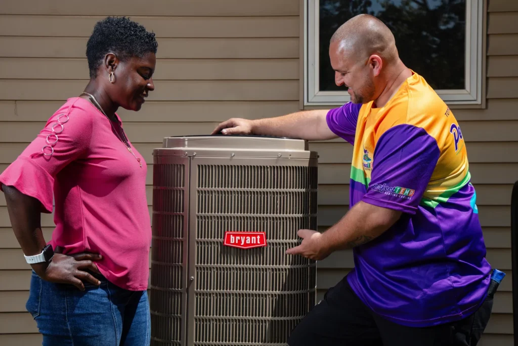 perfect temp worker next to homeowner and heat pump