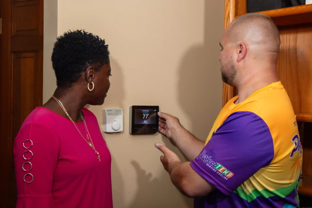 perfect temp worker showing thermostat to client