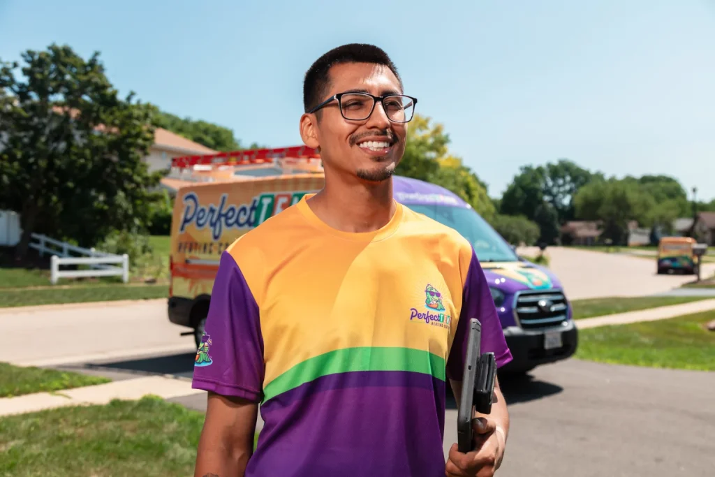 smiling technician next to perfect temp van