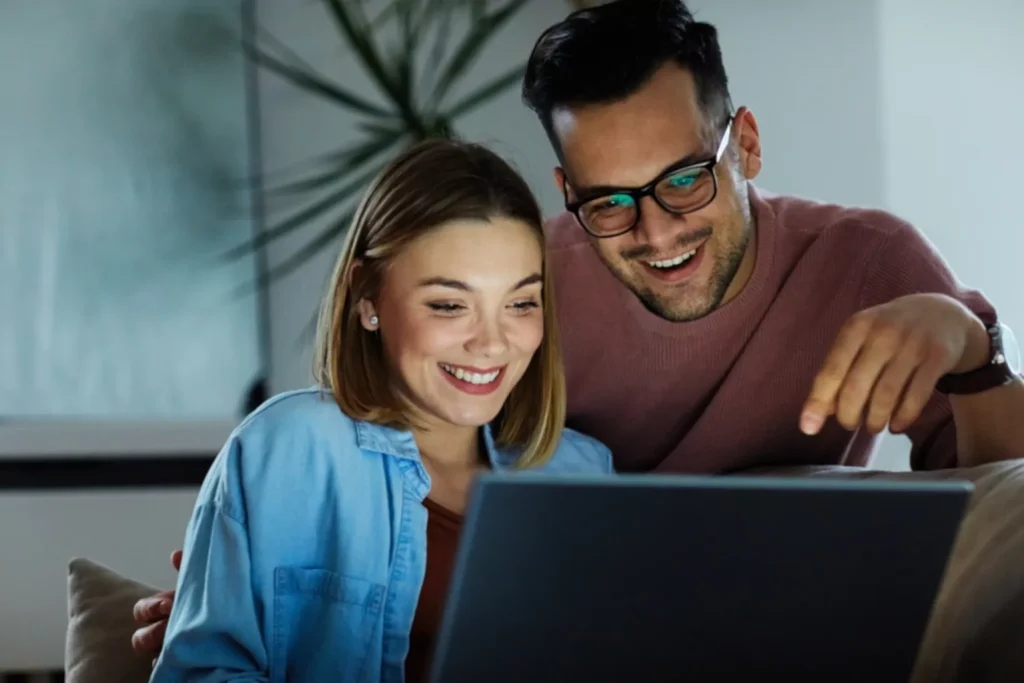 happy couple looking at laptop screen