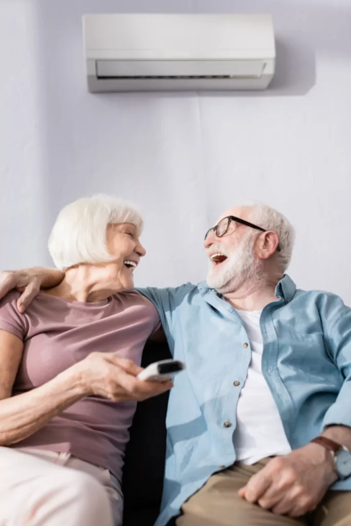 happy couple using air conditioner unit