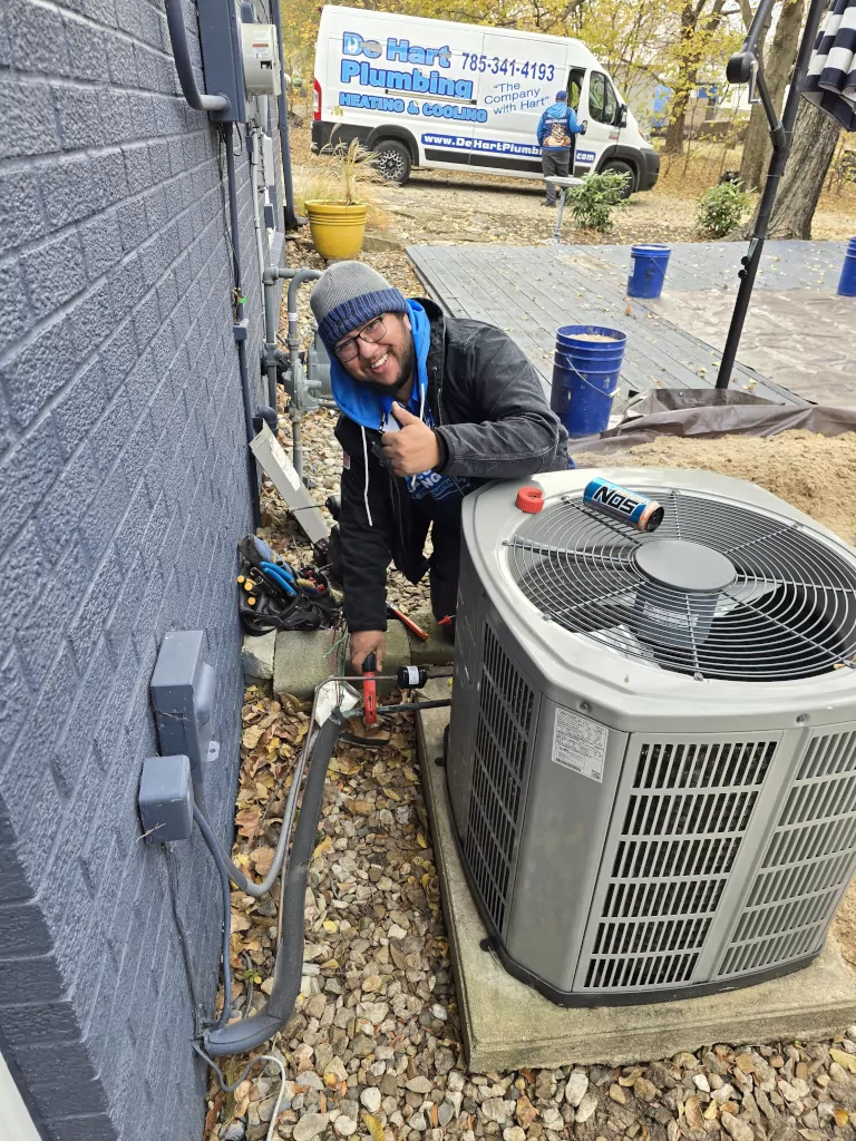 Technician servicing heat pump unit.