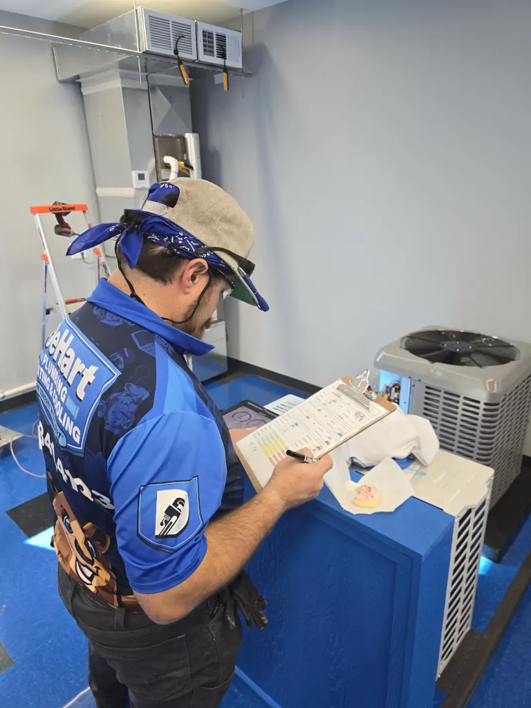 Technician reviewing heat pump checklist.