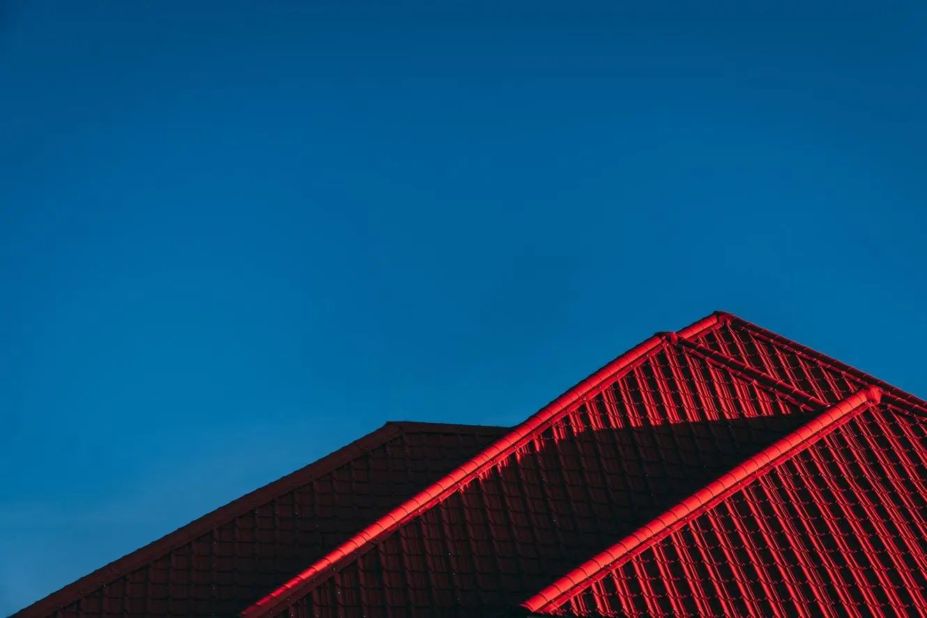 The red metal roof of a small home