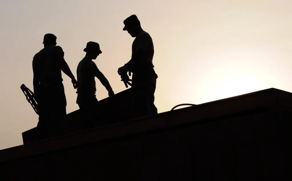 Three workmen on a roof.