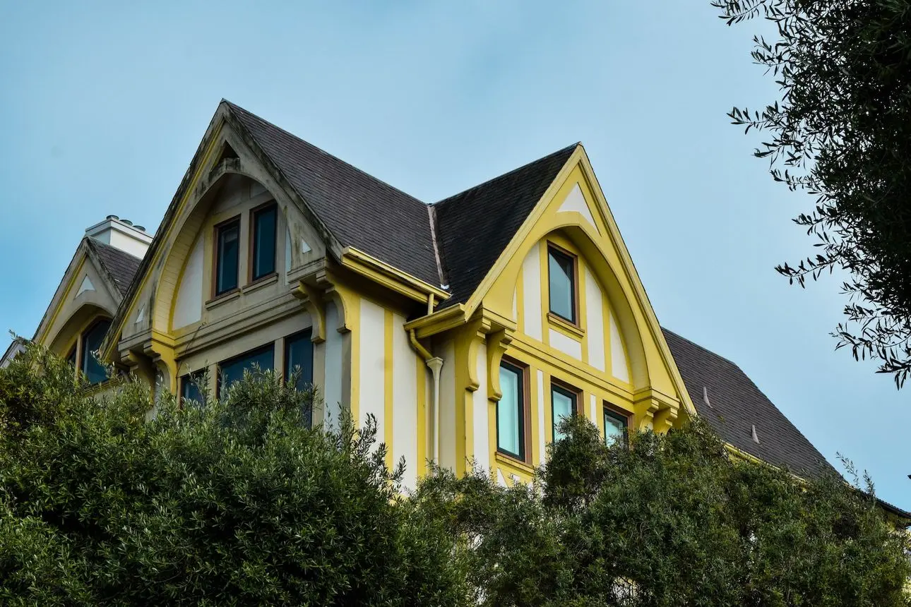 A yellow house that shows off the aesthetic impact of roof design