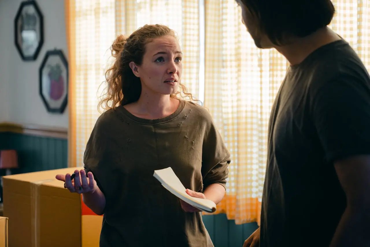 A woman holding a notepad talking to a man