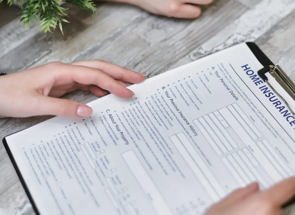 A person holding a home insurance form.