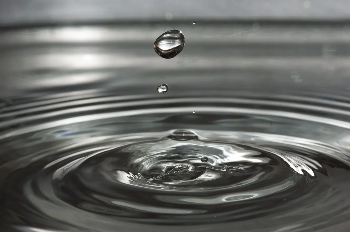 A drop of water falling into a pool of water.