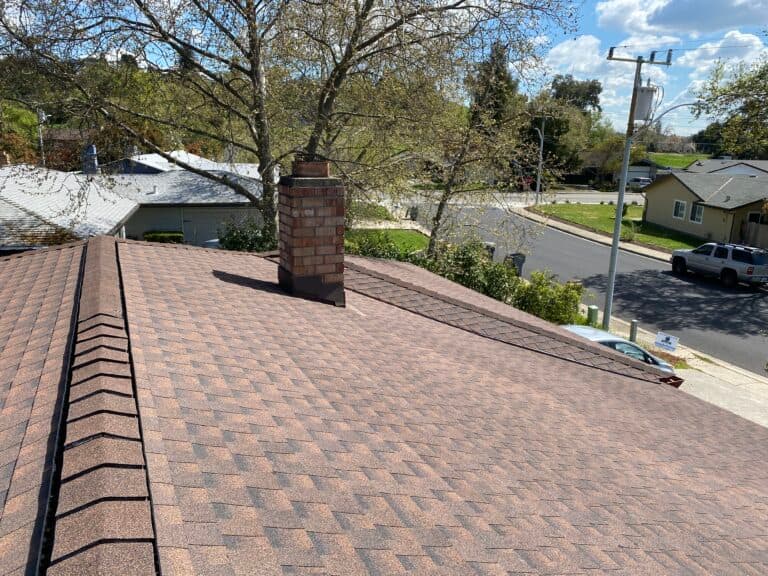 A tan shingle roof with a chimney
