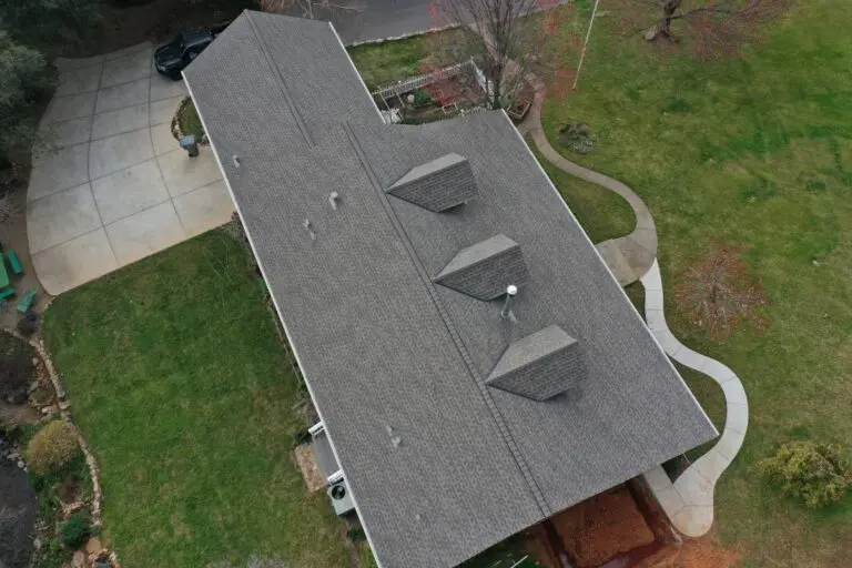 Aerial view of a large house with a dark grey shingle roof