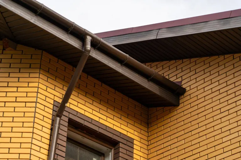 yellow brick wall gutter downspouts