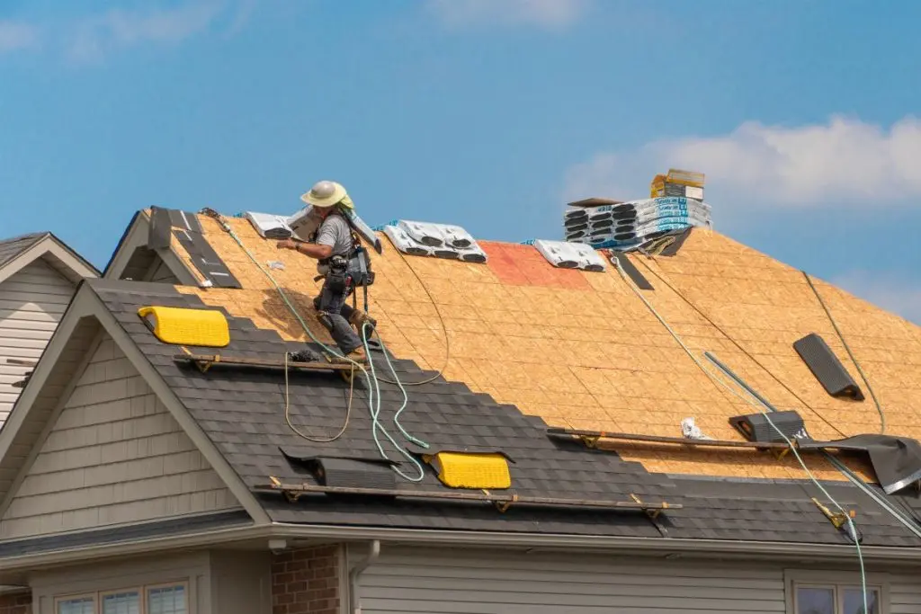 workers installing shingles roof