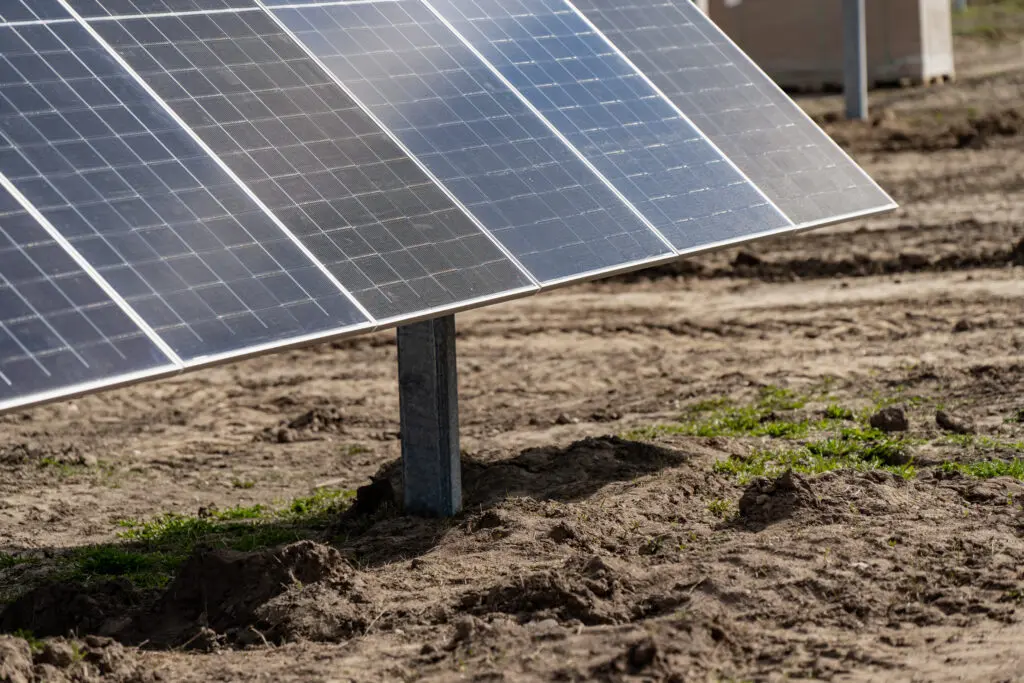 Solar panels installation on construction site ground for sustainable energy farm project and renewable electricity infrastructure development for industrial climate solutions