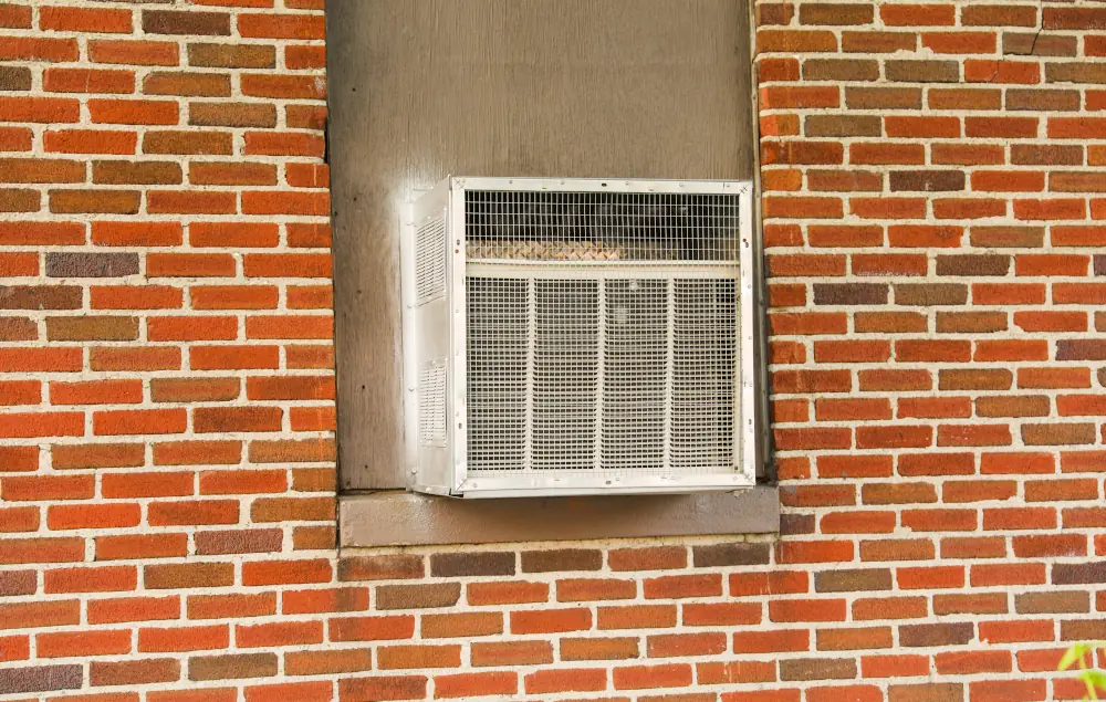 Why Should You Replace Your Old AC System With a Ductless Mini Split - Advantages Revealed by Strickland Heating and Air - Old AC unit on a window.
