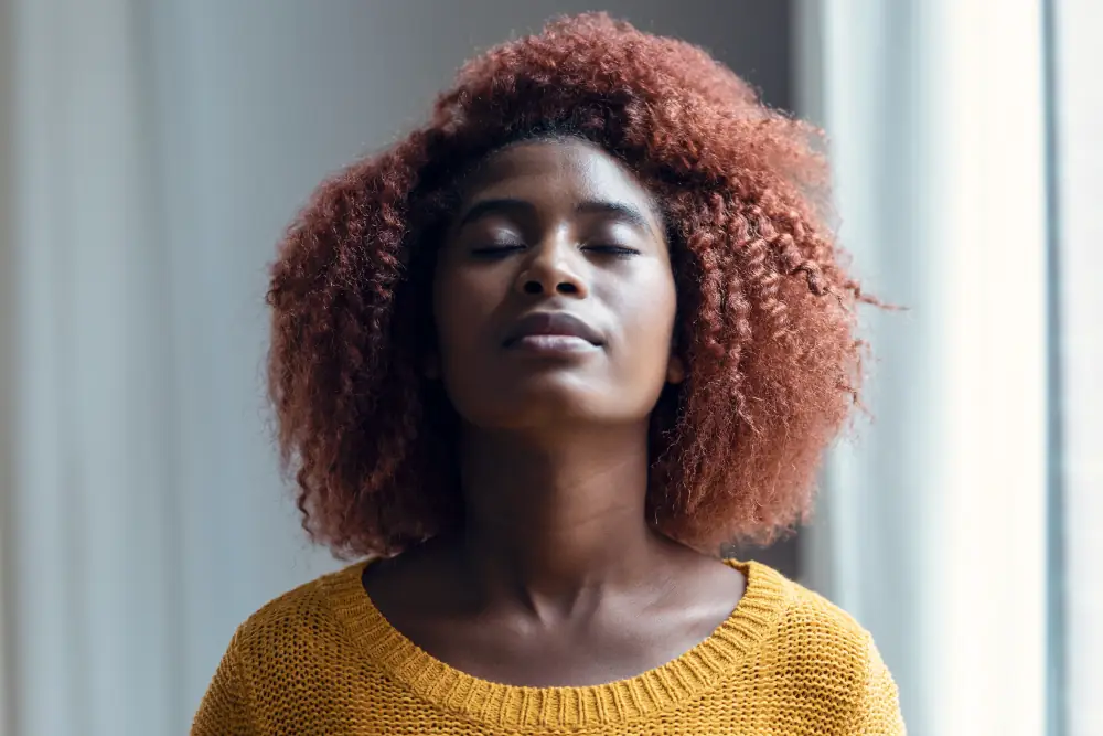 Breathing Easy: Understanding the Connection Between Your AC and Indoor Air Quality - Woman taking a deep breath