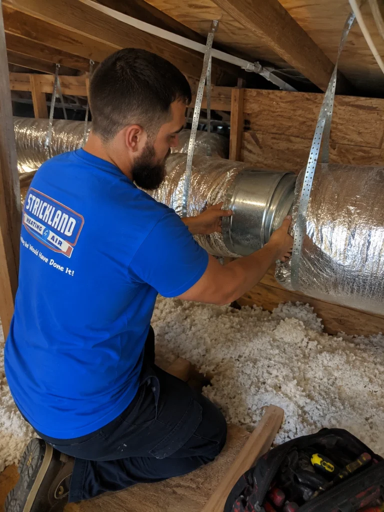 Strickland worker installing new ducts in the attic