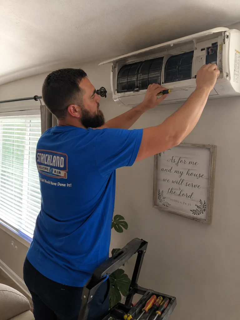 Strickland worker fixing a mini split unit