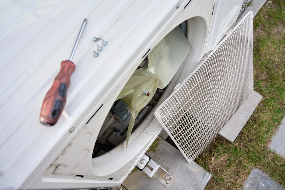 Top view of open outdoor heat pump unit with exposed fan