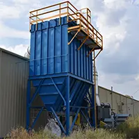 Blue industrial bulk storage silo with a staircase and access platform beside a warehouse, outdoors.