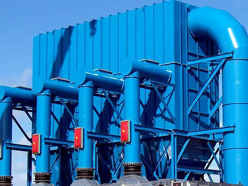 baghouse-biomass-combustible-dust | Sly Air Pollution Control Industrial blue metal pipes and support framework under a clear blue sky at an industrial facility.