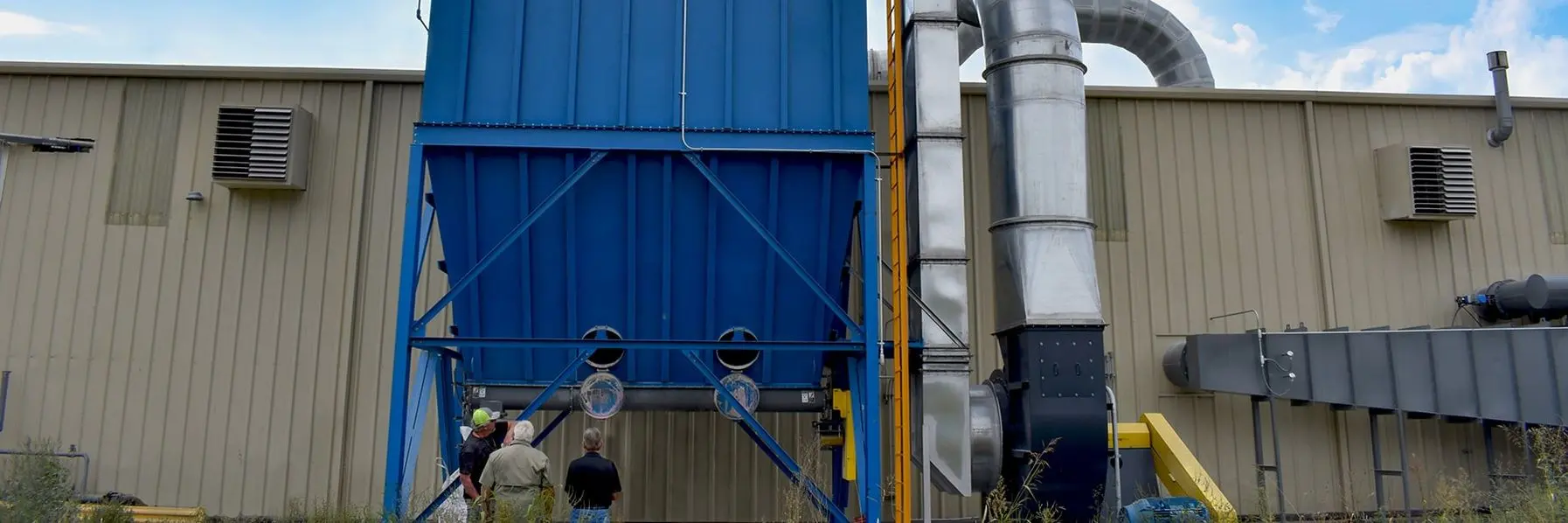 A technician performing a differential pressure check on an industrial baghouse A technician performing a differential pressure check on an industrial baghouse