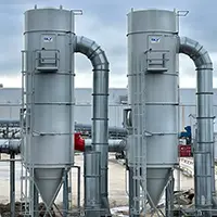 Two tall industrial filtration units on a rooftop, connected by large curved ducts.