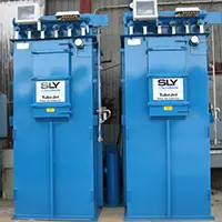 Two tall blue SLY-brand electrical transformers with control panels on top, installed side by side outdoors.