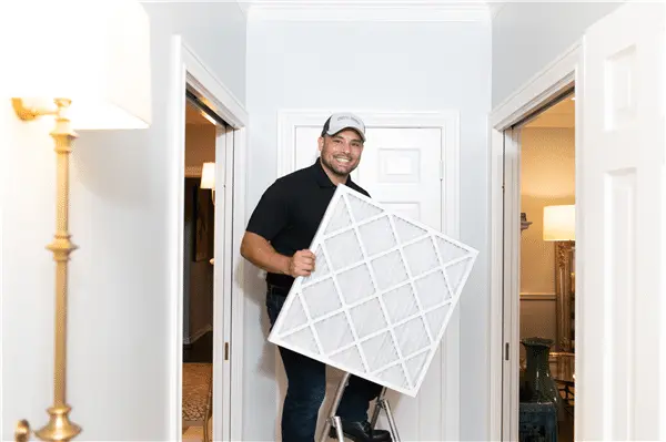 HVAC technician on ladder performing AC installation or repair service