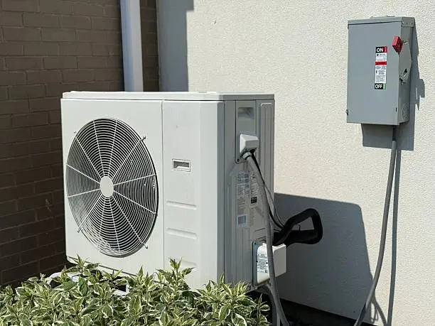 Modern HVAC air conditioner unit installed outdoors at residential property