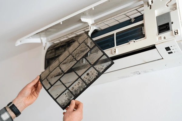 Dusty air conditioner filter showing need for immediate replacement and maintenance