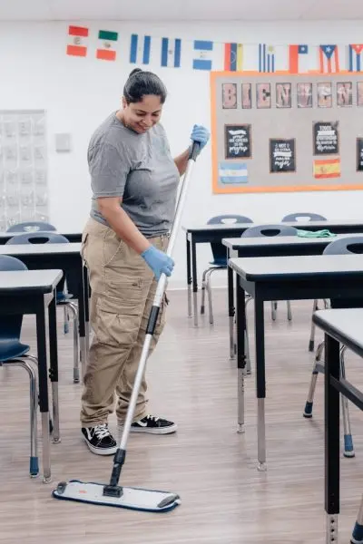 School janitor dust mopping classroom LVT floors