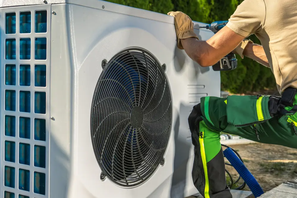Technician fixing a heat pump's outdoor unit