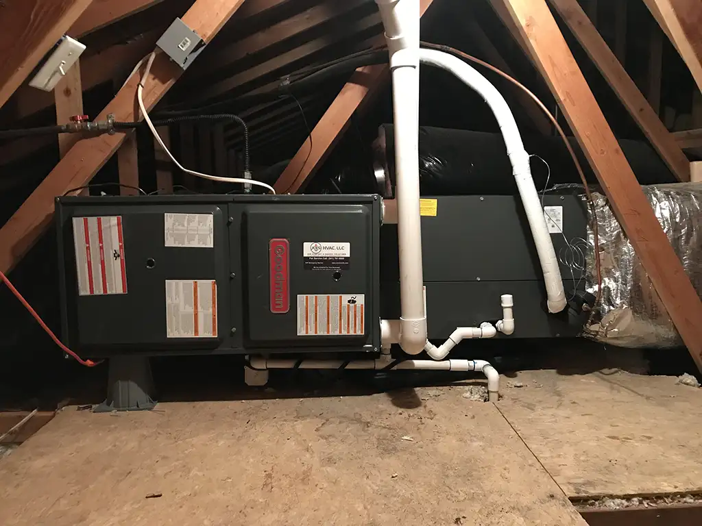 Heating system installed in an attic with wooden beams and ductwork.
