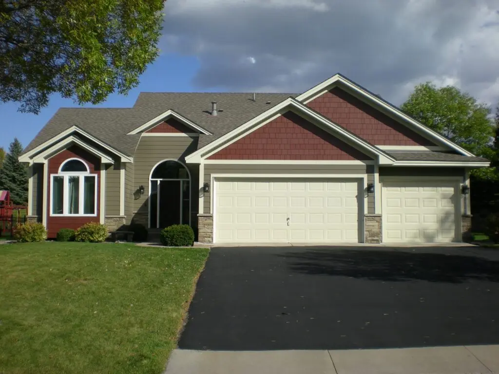 A house with green and red siding with white trim