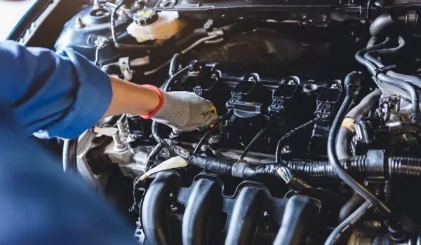 Car mechanic holding checking gear oil to maintenance vehicle by customer claim order in auto repair shop garage. Engine repair service. People occupation and business job. Automobile technician