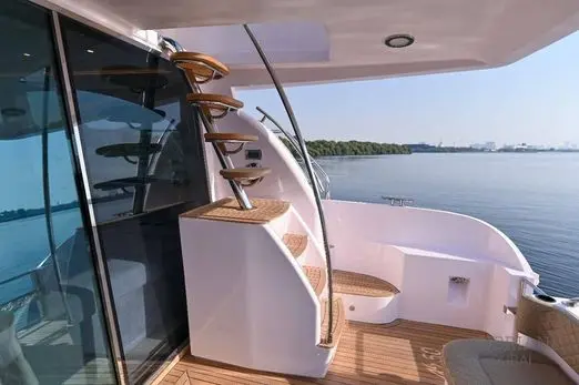 Teak staircase leading from the Novia 55 aft deck up to the flybridge beside the tinted salon doors