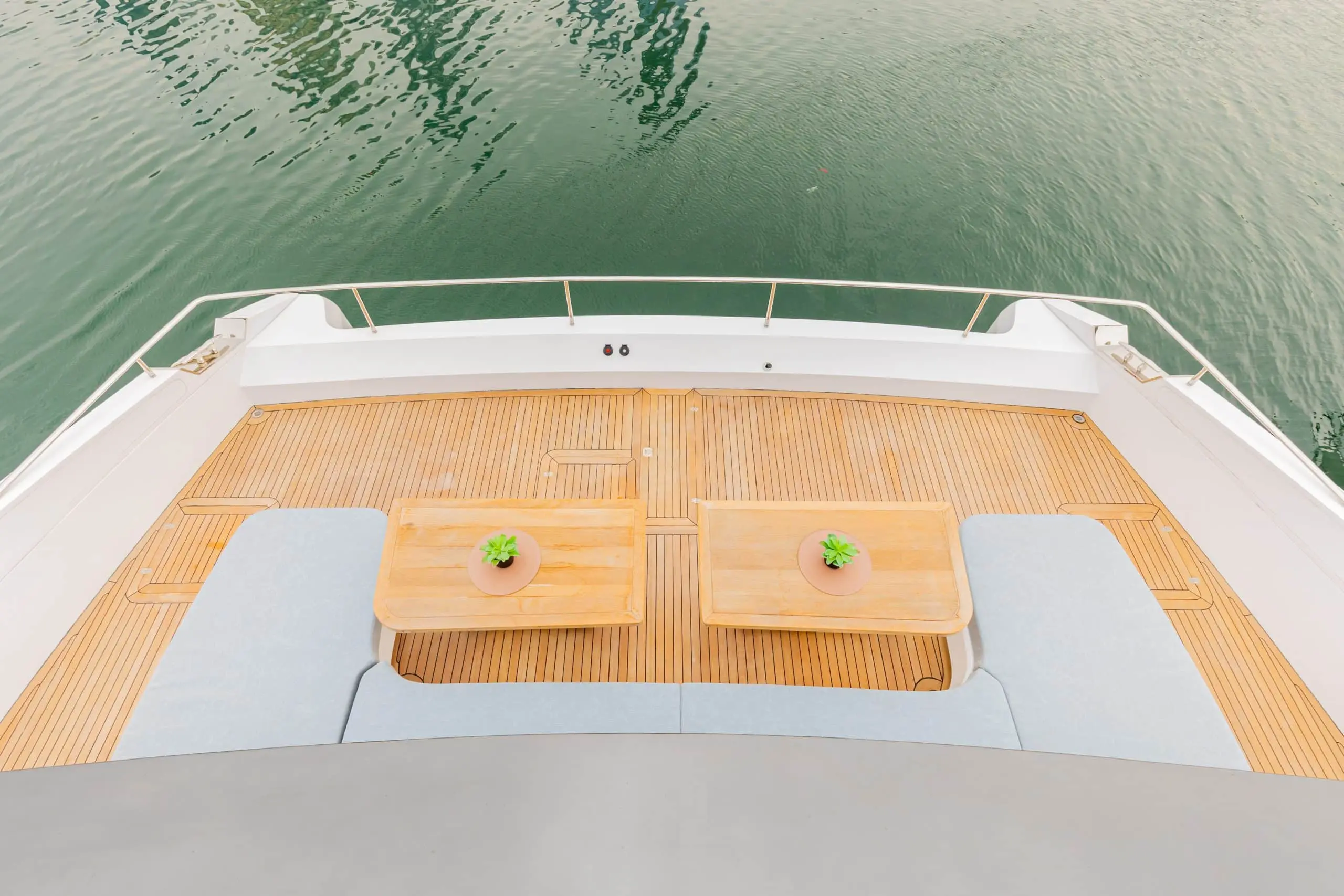 Zirve 72 yacht aft deck seating area with wooden table overlooking calm sea