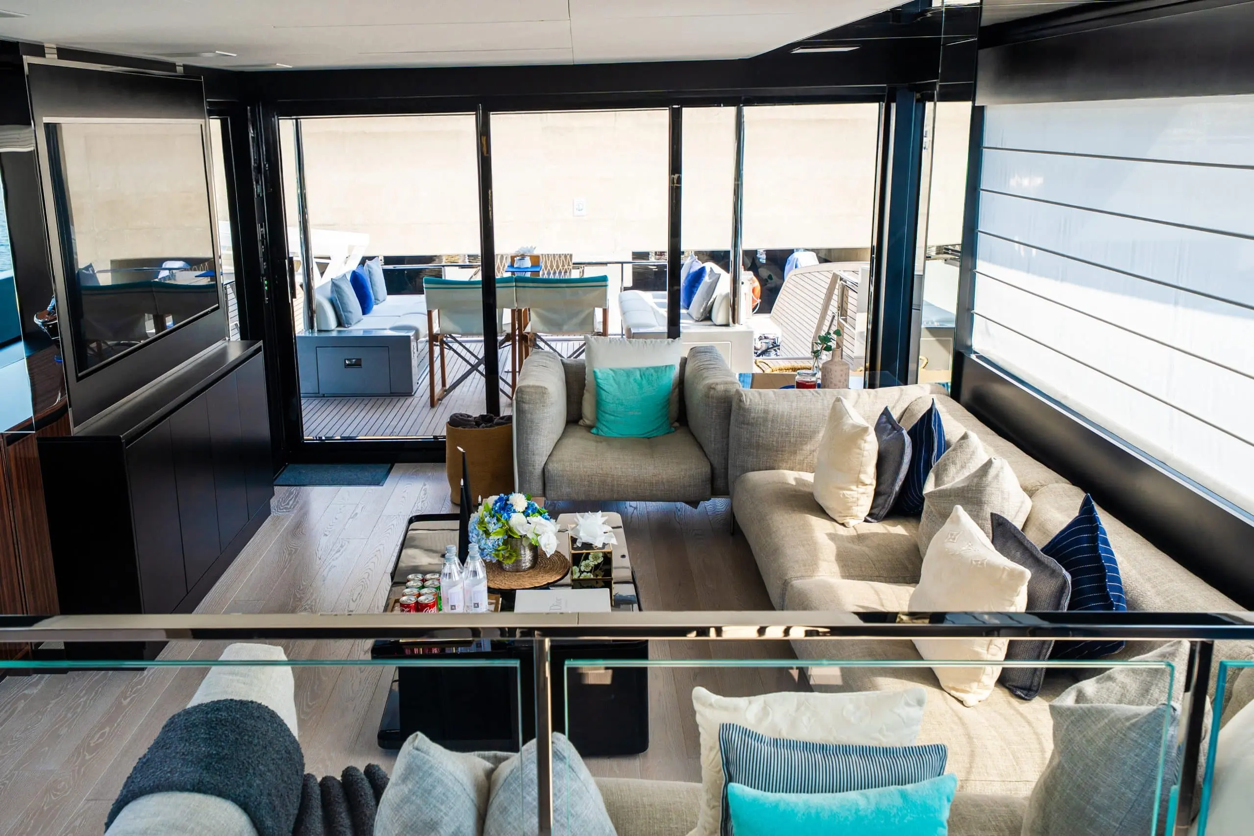 Riva 82 F1 yacht salon interior with modern sofa seating, panoramic glass doors, and aft deck view