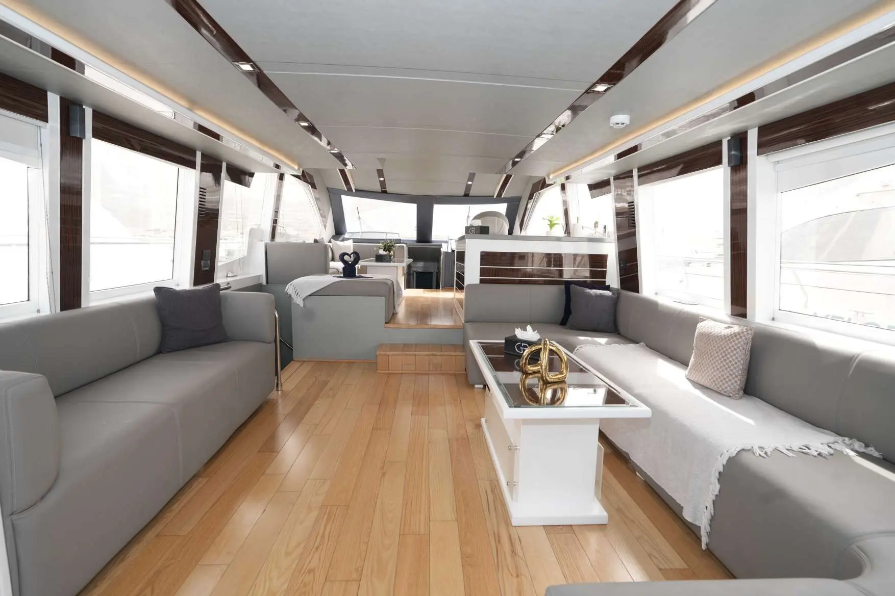 Belle 75 yacht interior with spacious lounge and wood flooring.
